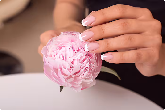 Woman hands with french manicure and flowers